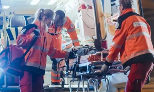 EMS Team of Associate Degree Paramedics 加载 Injured Patient Into Ambulance